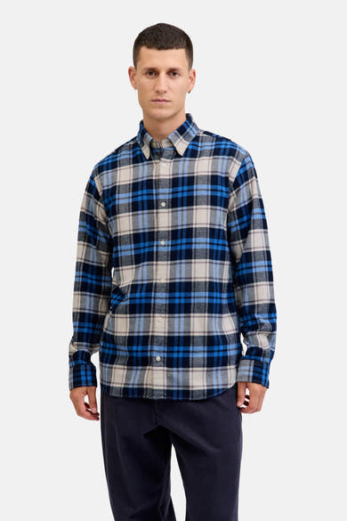 Blauw overhemd met lange mouwen van JACK & JONES met ruitpatroon gedragen met een peacoat en een marineblauwe broek.