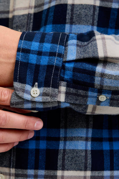 Blauw geruit overhemd met lange mouwen van JACK & JONES, met witte knoop, close-up.