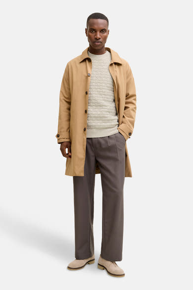 Pull col rond en maille torsadée par JACK & JONES, porté avec un manteau camel et un pantalon gris.

