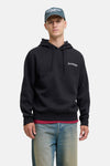 Zwarte hoodie van Jack & Jones, gedragen met een spijkerbroek en een pet.