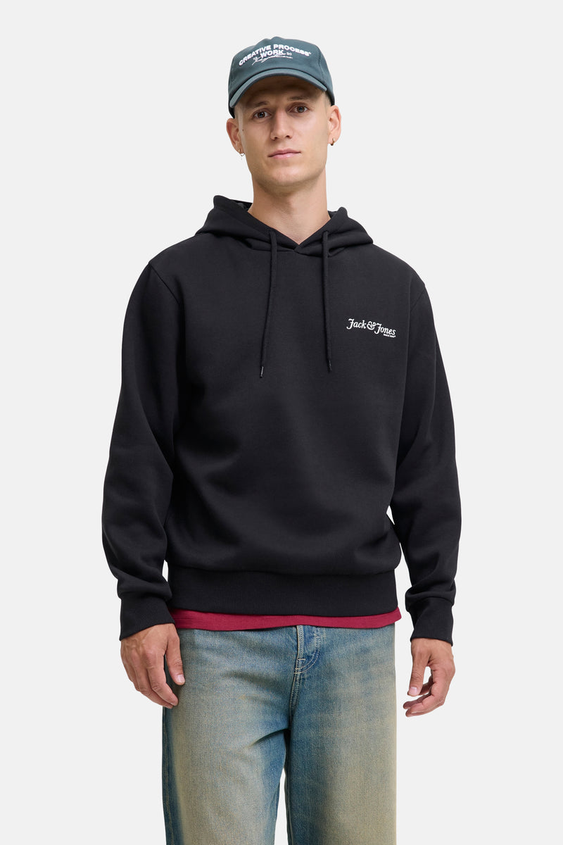 Zwarte hoodie van Jack & Jones, gedragen met een spijkerbroek en een pet.