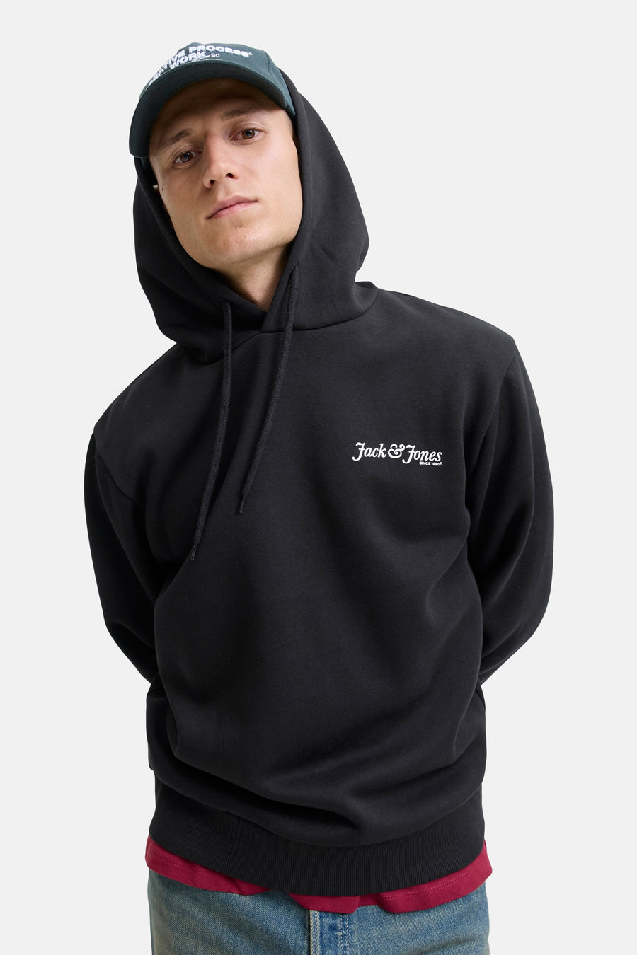 Zwarte hoodie van JACK & JONES met trekkoord en borstlogo, gedragen over een bordeauxrood T-shirt.