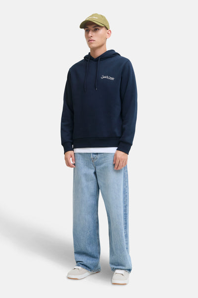 Sweat à capuche bleu marine de JACK & JONES, porté avec un jean ample bleu clair et une casquette kaki.

