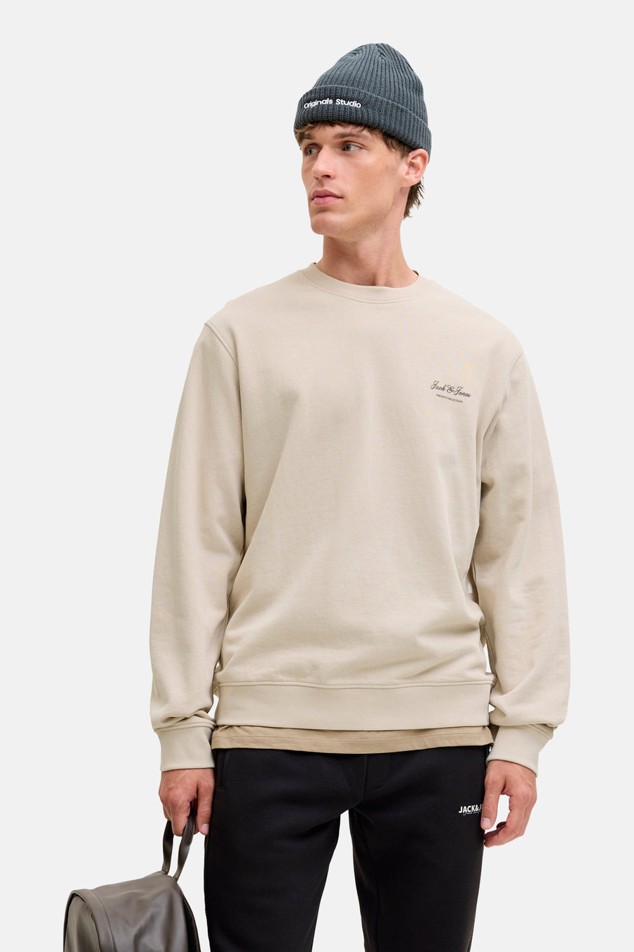 Sweat beige à col rond de Originals by Jack & Jones, porté avec un bonnet et un pantalon noirs.
