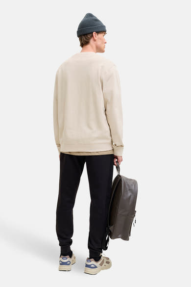 Sweat-shirt beige par ORIGINALS BY JACK & JONES, avec pantalon noir et sac à dos en cuir.