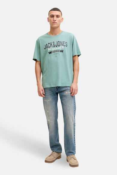 T-shirt à manches courtes bleu d'ORIGINALS BY JACK & JONES, avec un logo imprimé sur le devant, porté avec un jean décontracté.
