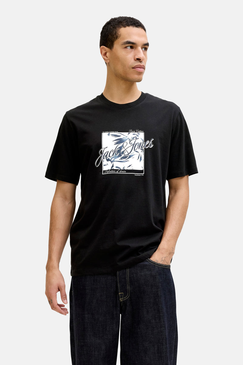 T-shirt à manches courtes noir de JACK & JONES, avec imprimé graphique encadré, porté avec un jean foncé.
