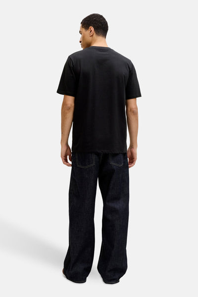 T-shirt noir à manches courtes de JACK & JONES, porté avec un jean ample bleu foncé.