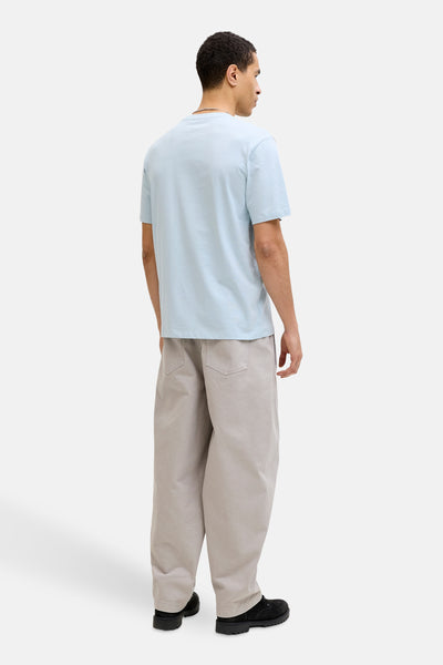 T-shirt à manches courtes bleu de JACK & JONES, porté avec un pantalon ample beige et des bottines noires, vue de dos.
