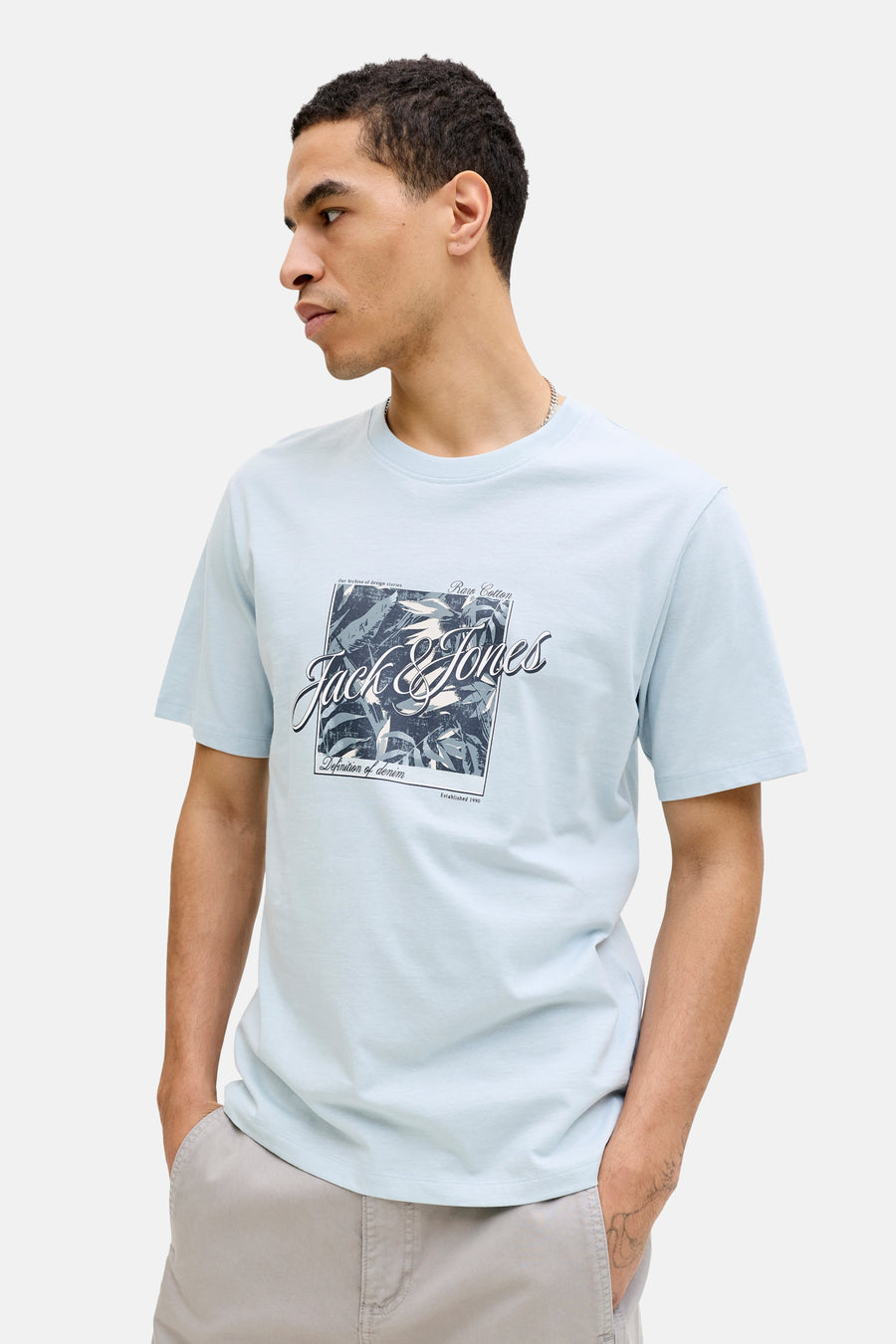 Blauw T-shirt met korte mouwen van JACK & JONES met grafische print op de voorkant, gedragen met een beige broek.