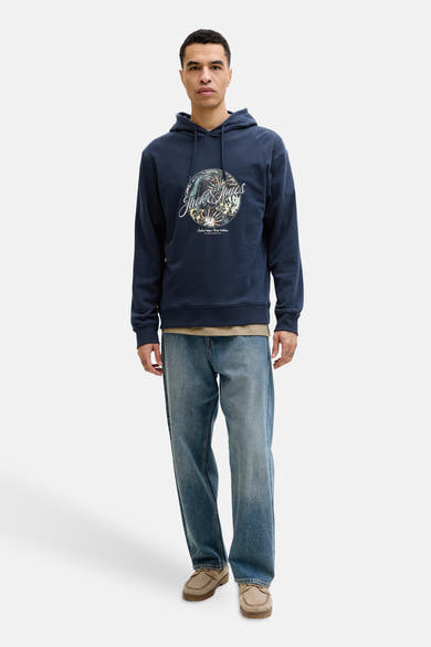 Sweat à capuche bleu de Jack & Jones, avec motif imprimé sur le devant, porté avec un jean décontracté.