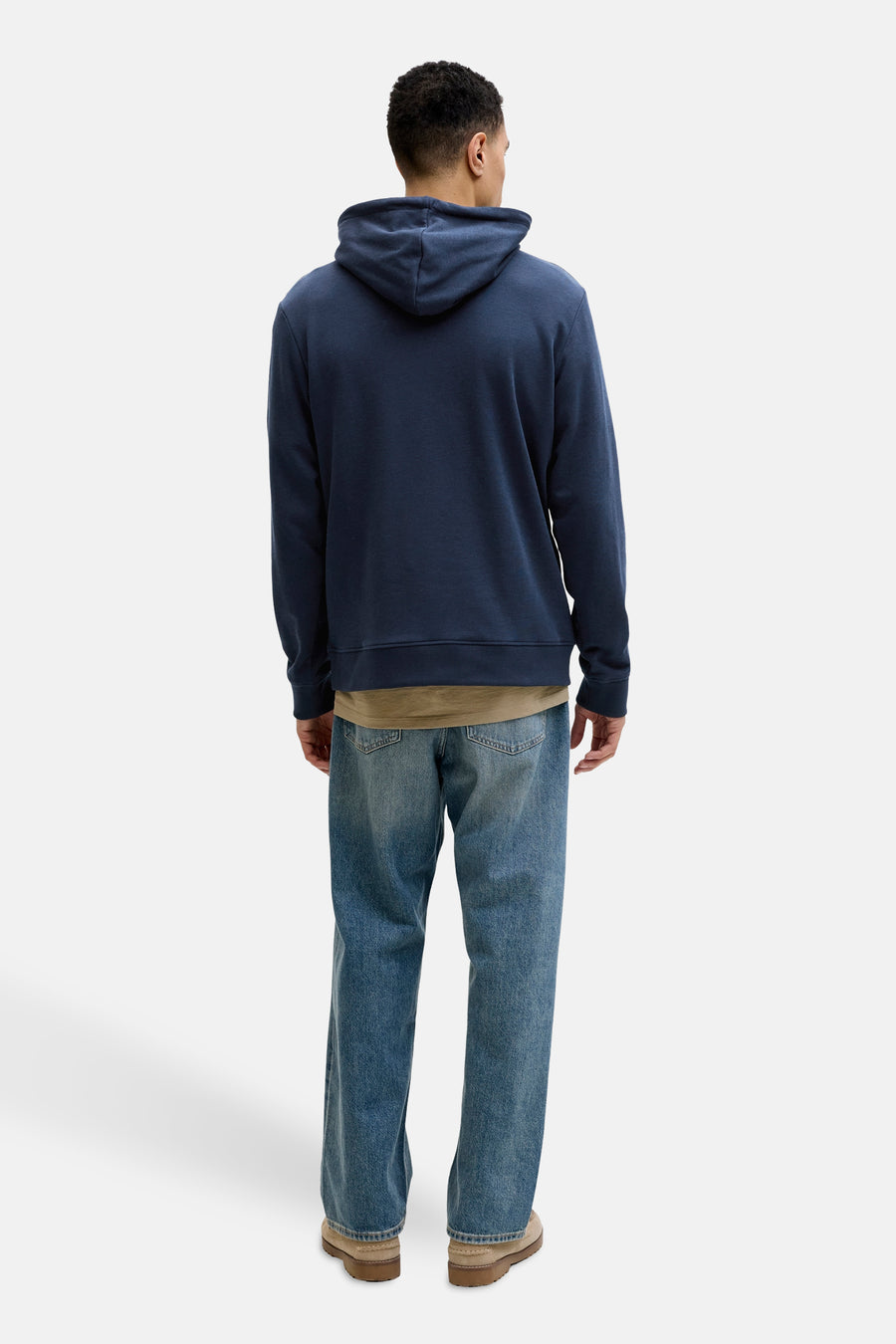 Blauwe hoodie van JACK & JONES, gedragen met een beige T-shirt en een blauwe jeans, van achteren gezien.