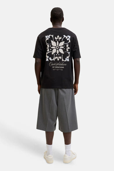 T-shirt noir à manches courtes de ORIGINALS BY JACK & JONES, avec un motif floral blanc et bleu clair et l'inscription 'Our Archive' au dos.