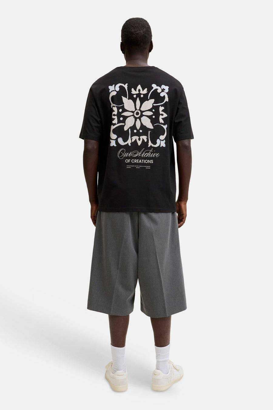 T-shirt noir à manches courtes de ORIGINALS BY JACK & JONES, avec un motif floral blanc et bleu clair et l'inscription 'Our Archive' au dos.