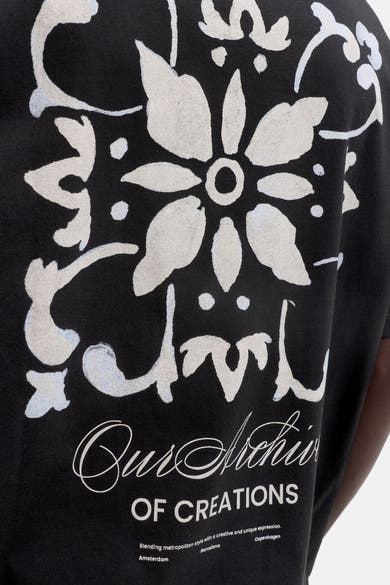 T-shirt noir d'ORIGINALS BY JACK & JONES avec grand motif ornemental blanc cassé et texte imprimé au dos.