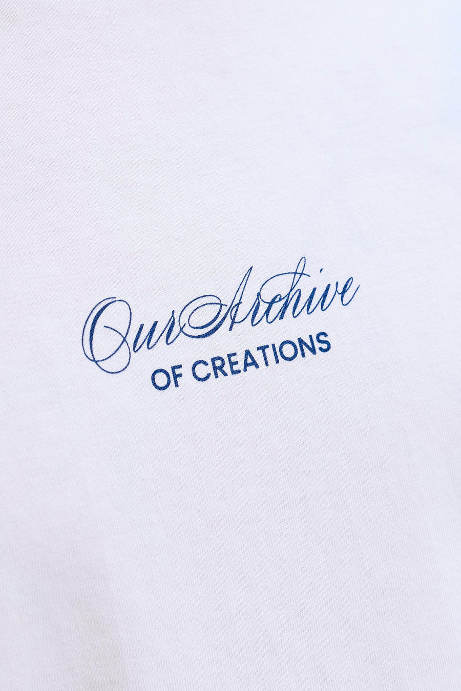 T-shirt blanc d'ORIGINALS BY JACK & JONES avec un imprimé bleu en diagonale "Our Archive OF CREATIONS".