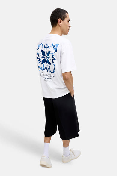 T-shirt blanc d'ORIGINALS BY JACK & JONES, vue de dos, avec motif floral bleu et inscription 'An Artistic CREATION'.