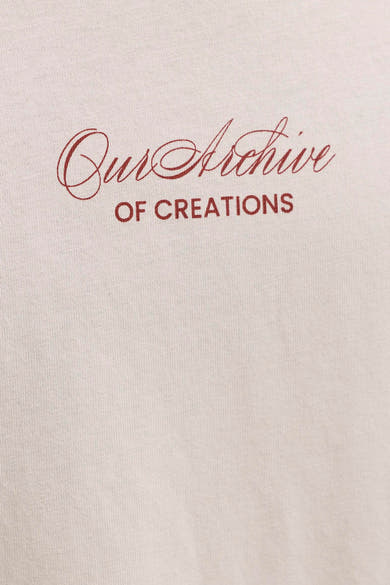 T-shirt beige de ORIGINALS BY JACK & JONES avec impression rouge "Our Archive OF CREATIONS" et texture tricotée visible.
