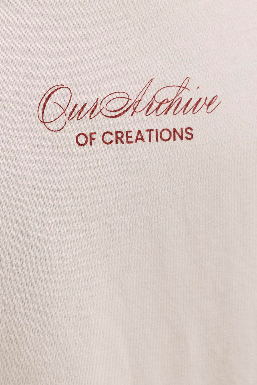 T-shirt beige de ORIGINALS BY JACK & JONES avec impression rouge "Our Archive OF CREATIONS" et texture tricotée visible.