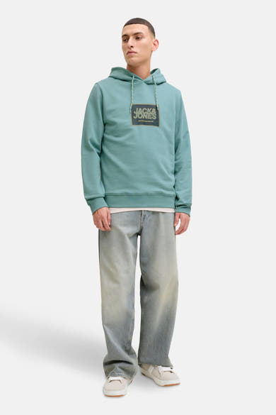 Sweat à capuche vert de JACK & JONES, porté avec un jean délavé et des baskets blanches.