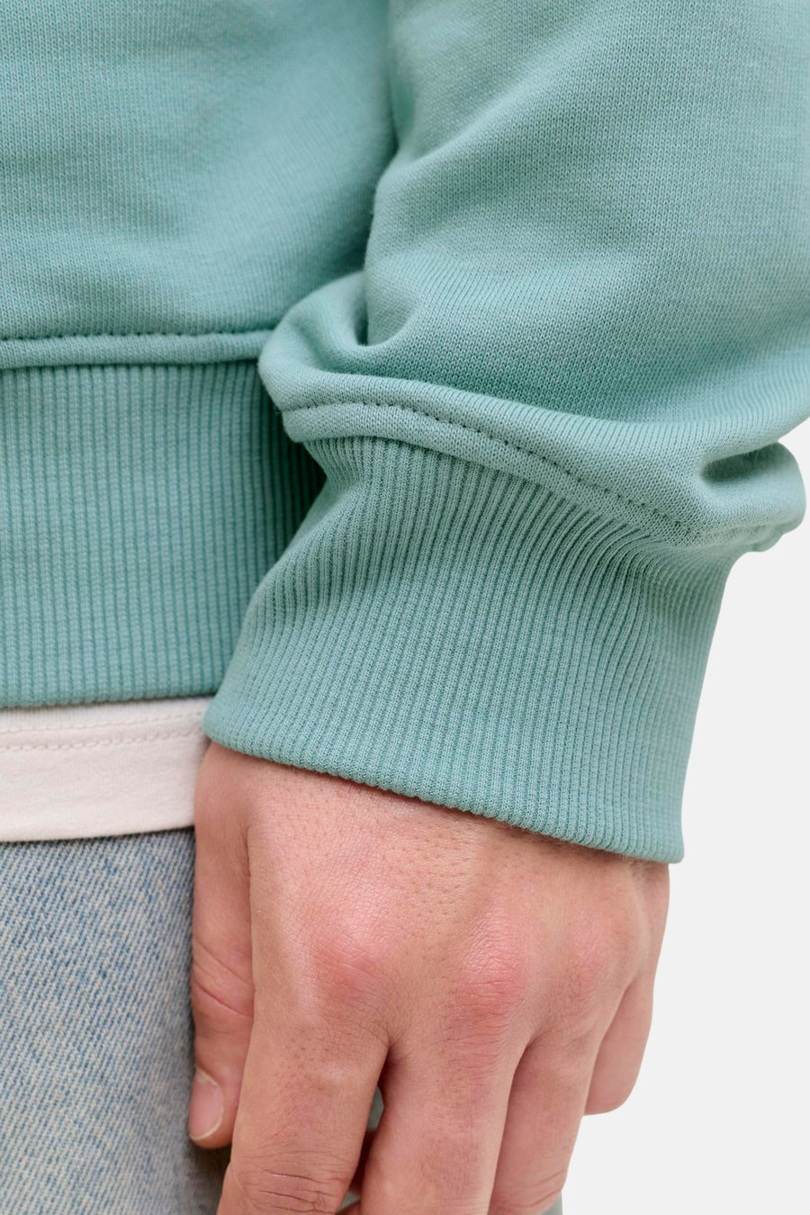 Groene sweater van JACK & JONES, geribde trui-mouw, gedragen met een wit T-shirt en een spijkerbroek.