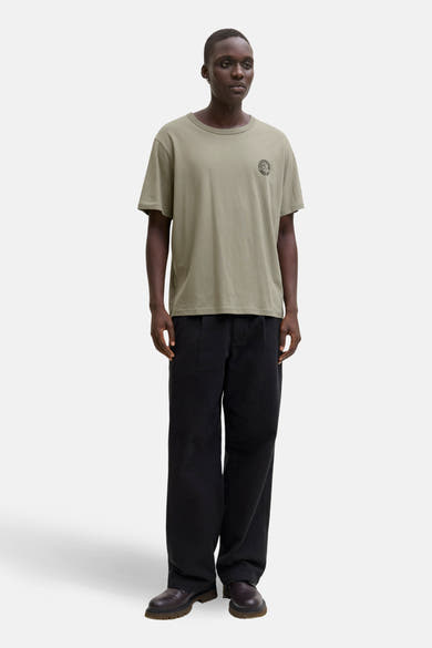 Groen T-shirt met korte mouwen van ORIGINALS BY JACK & JONES met een logo op de borst, gedragen met een wijde zwarte broek.