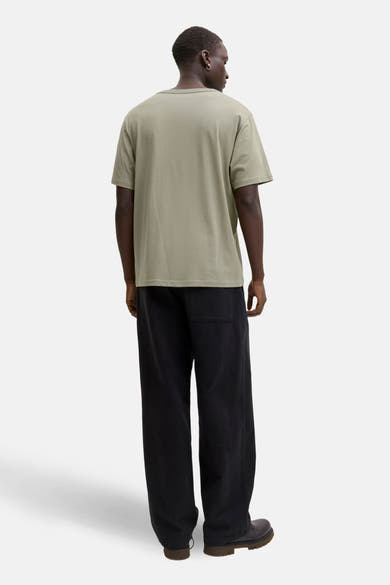 Olijfgroen T-shirt met korte mouwen van ORIGINALS BY JACK & JONES, gedragen met een zwarte wijde broek en bruine laarzen, achtergezicht.