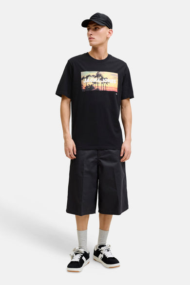 T-shirt noir de JACK & JONES avec un imprimé graphique de coucher de soleil, palmiers et le texte "JACK & JONES".