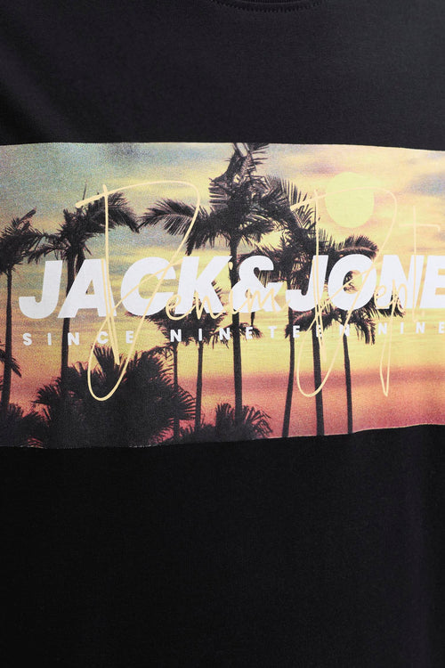T-shirt noir de JACK & JONES avec un imprimé graphique de coucher de soleil et de palmiers, superposé du texte blanc 'JACK & JONES SINCE NINETEEN NINETY NINE'.