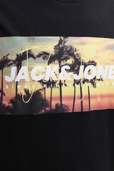 T-shirt noir de JACK & JONES avec un imprimé graphique de coucher de soleil et de palmiers, superposé du texte blanc 'JACK & JONES SINCE NINETEEN NINETY NINE'.
