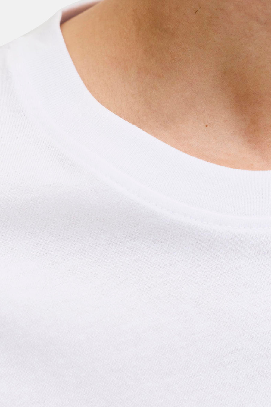T-shirt blanc de JACK & JONES, gros plan sur le col côtelé et le cou avec un grain de beauté.