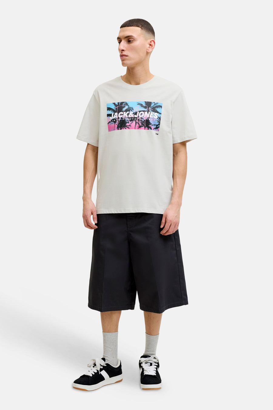 T-shirt blanc de JACK & JONES avec imprimé graphique de palmiers en dégradé rose-bleu et logo.