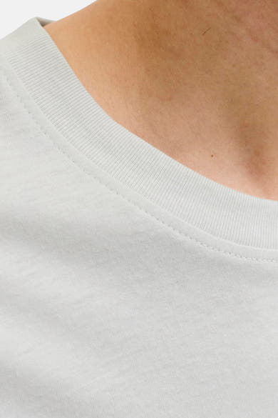 T-shirt blanc de JACK & JONES, plan rapproché sur l'encolure ras-du-cou côtelée et les piqûres apparentes sur la peau.