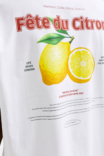 White short-sleeve t-shirt with vibrant lemon graphic and "Fête du Citron" text, by Jack & Jones traditions, featuring red lettering and green leaves, close-up front view