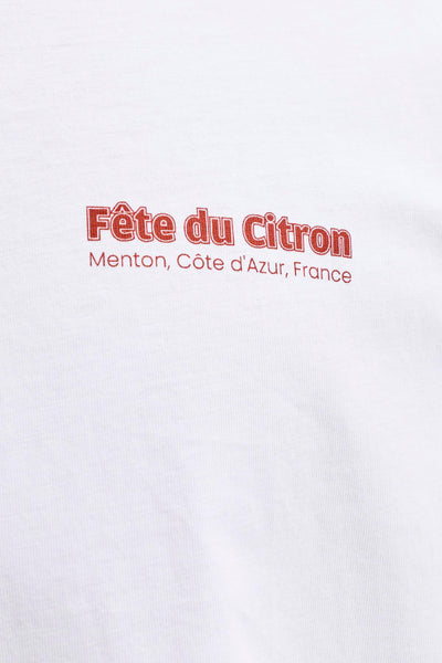 White short-sleeve t-shirt with red "Fête du Citron" text print, Menton Côte d'Azur France, close-up front view