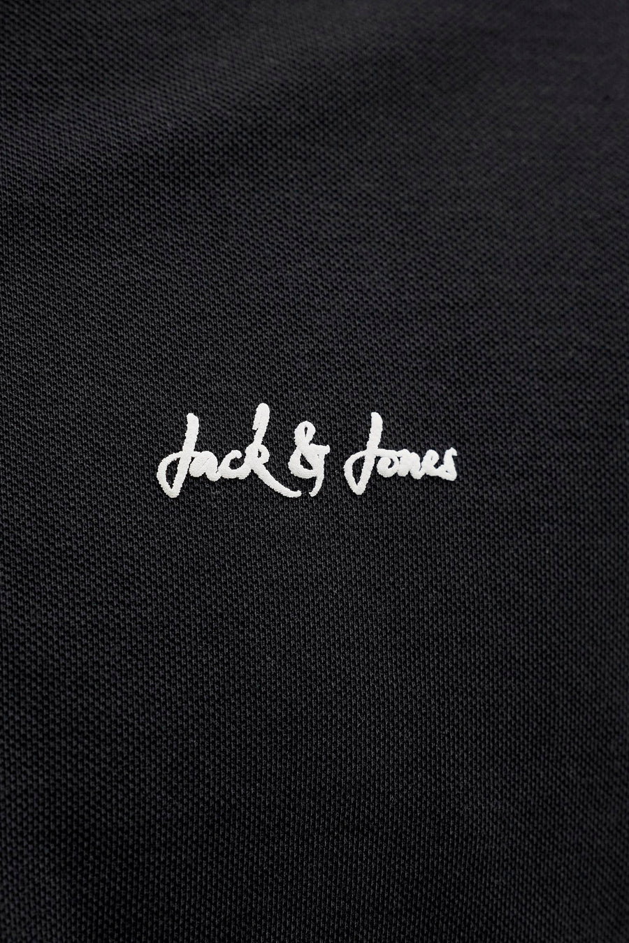 Polo noir de JACK & JONES avec logo brodé blanc sur tissu texturé.