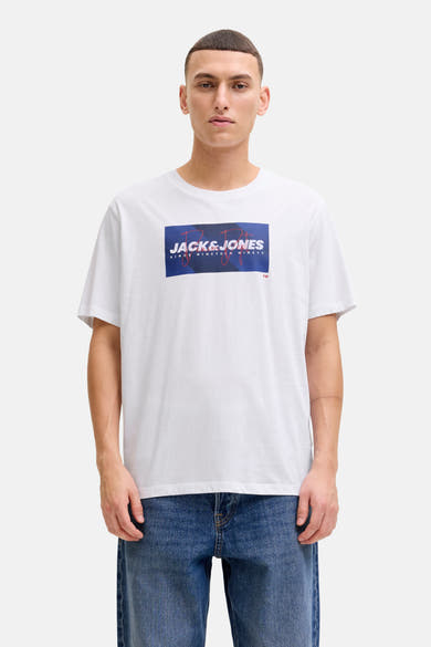 Wit T-shirt met korte mouwen van JACK & JONES, gedragen met een blauwe spijkerbroek en beige bootschoenen.