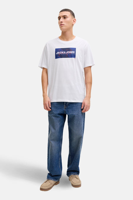T-shirt à manches courtes blanc de JACK & JONES, porté avec un jean bleu et des chaussures bateau beiges.
