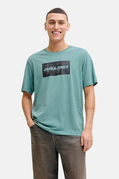 T-shirt bleu à manches courtes de JACK & JONES, avec un imprimé graphique sur le devant et un pantalon marron.