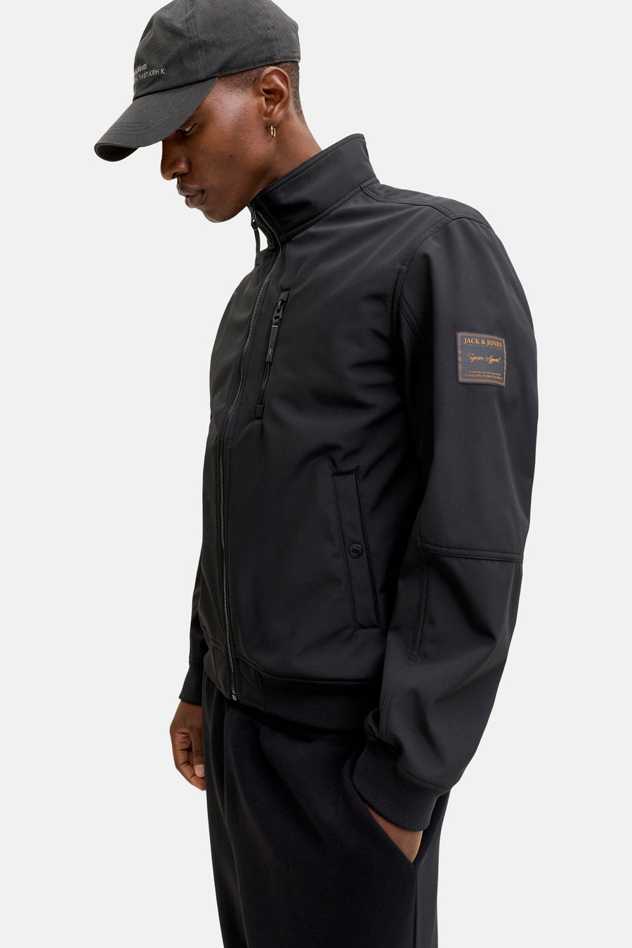 Zwarte regenjas van ORIGINALS BY JACK & JONES met ritssluiting, zak en decoratieve patch op de mouw.