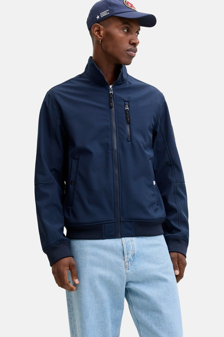 Blauwe regenjas van ORIGINALS BY JACK & JONES met ritssluiting, gedragen over een wit T-shirt en een wijde jeans.