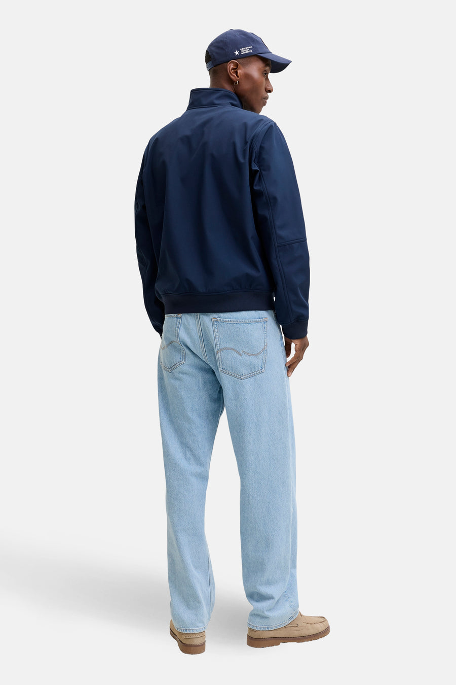 Veste de pluie bleue par Originals by Jack & Jones, portée avec un jean décontracté et des chaussures bateau.