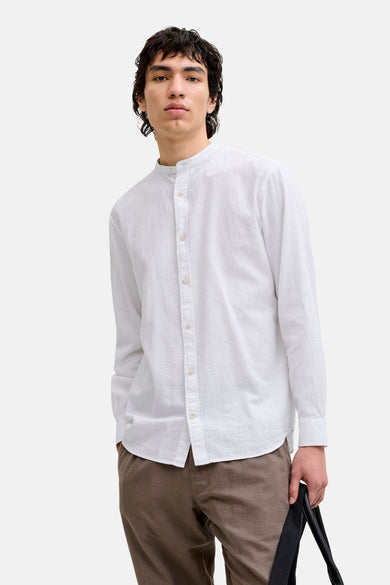 Chemise blanche (manches longues) de JACK & JONES, portée avec un pantalon marron.