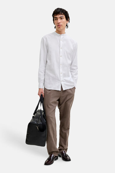 Chemise à manches longues blanche de JACK & JONES, portée avec un pantalon marron et des mocassins.