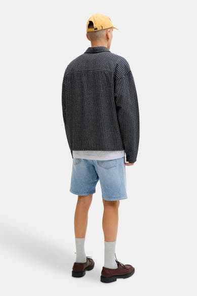 Short en denim bleu clair de JACK & JONES JEANS INTELLIGENCE, porté avec une chemise à carreaux, des chaussettes grises et des chaussures marron.