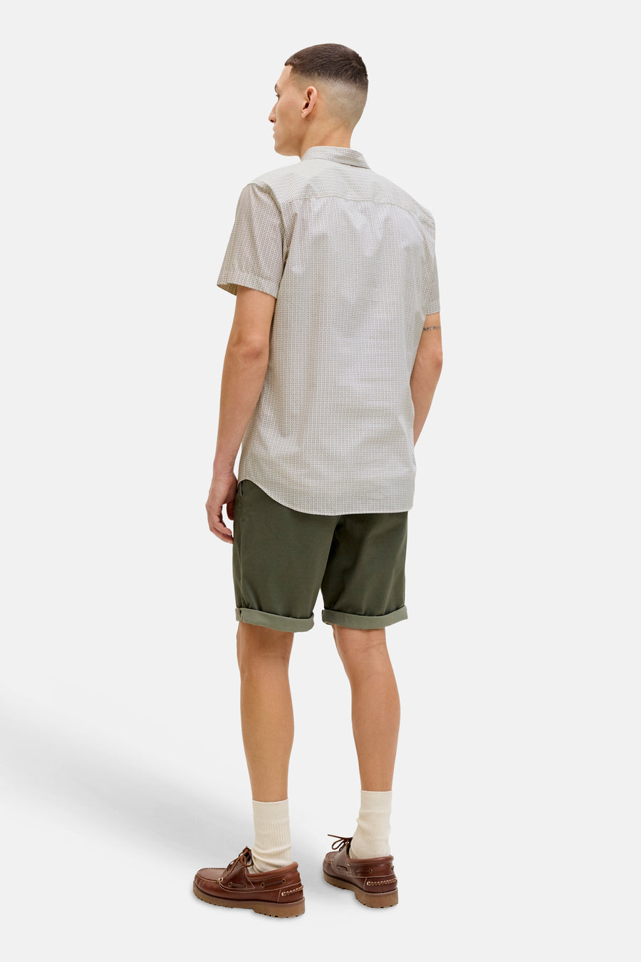 Chemise beige à manches courtes de PREMIUM by JACK & JONES, motif à petits points, portée avec un short vert olive et des chaussures bateau.