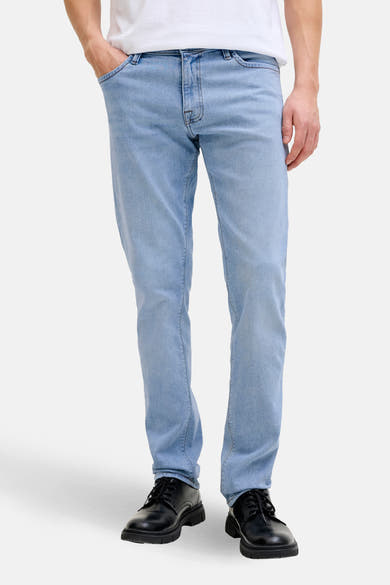 Jean slim en denim bleu clair de JACK & JONES JEANS INTELLIGENCE, porté avec un t-shirt blanc et des chaussures noires.