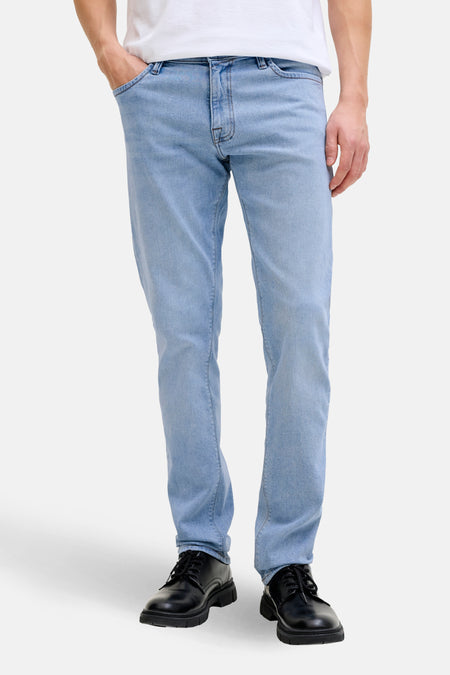 Slim jeans in lichtblauw denim van JACK & JONES JEANS INTELLIGENCE, gedragen met een wit T-shirt en zwarte schoenen.