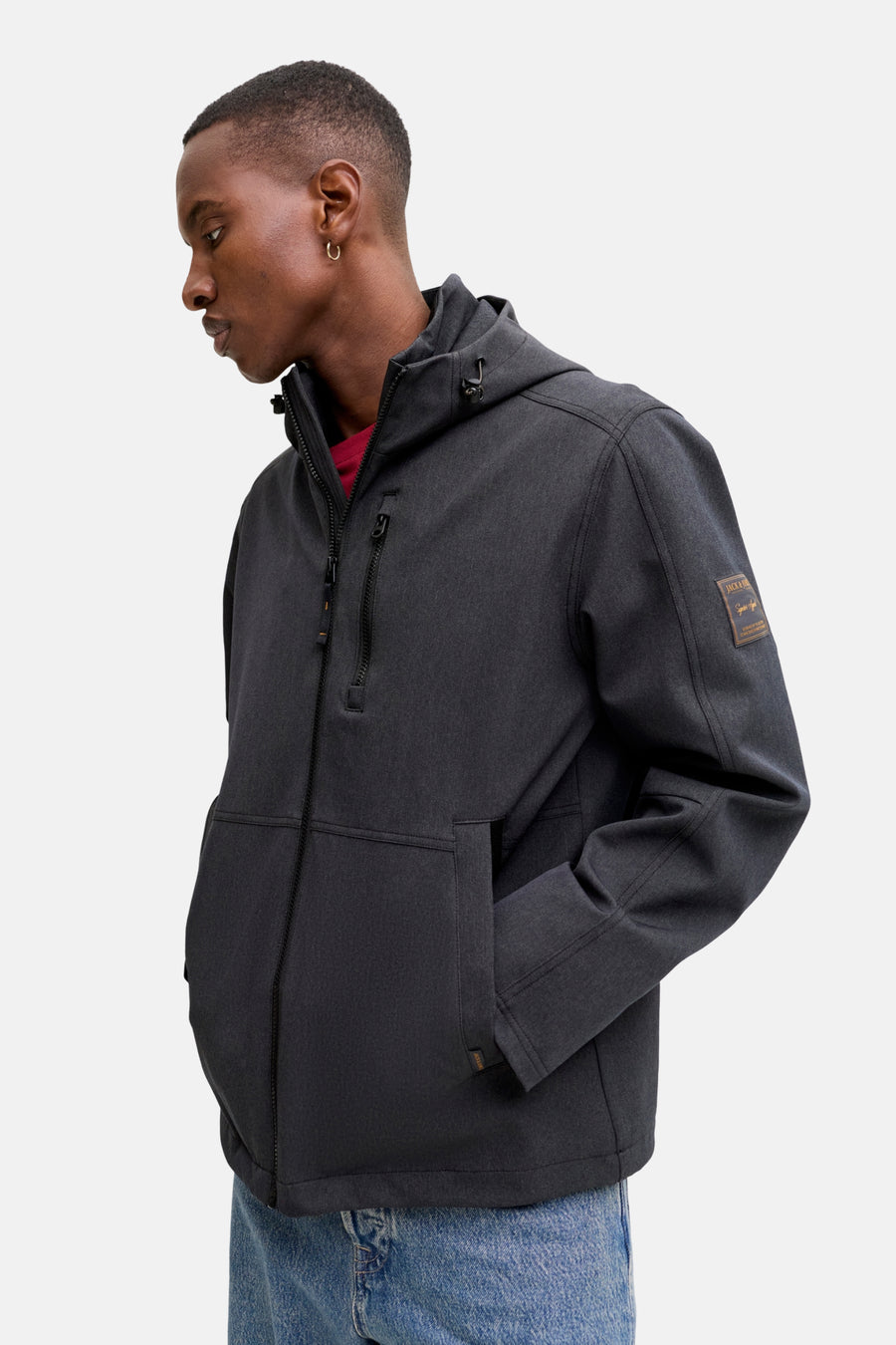 Korte grijze jas van ORIGINALS BY JACK & JONES met capuchon en zakken, gedragen met een rood T-shirt en een spijkerbroek.