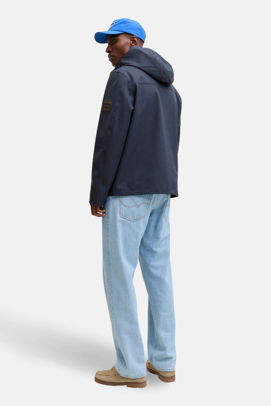 Veste courte bleue par ORIGINALS BY JACK & JONES, avec capuche, portée avec un chapeau bleu et un jean bleu clair.
